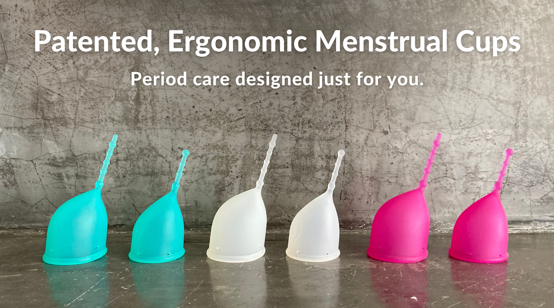 Patented, ergonomic menstrual cups. Period care designed just for you. Photo of Kind Cup menstrual cups full product lineup shown in profile against a dark gray cement background.