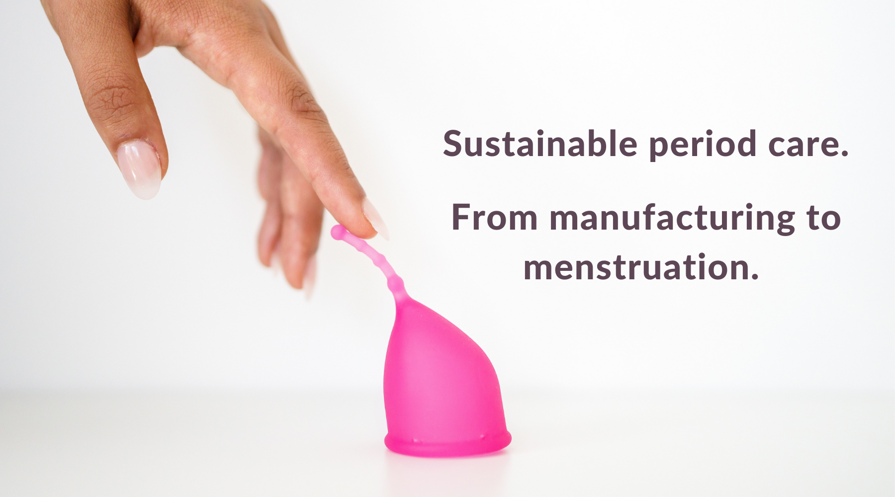 Sustainable period care. From manufacturing to menstruation. With Kind menstrual cup. Image of a Black woman's hand gently touching the soft, flexible, long removal stem of Kind Cup with ergonomic curves and design.
